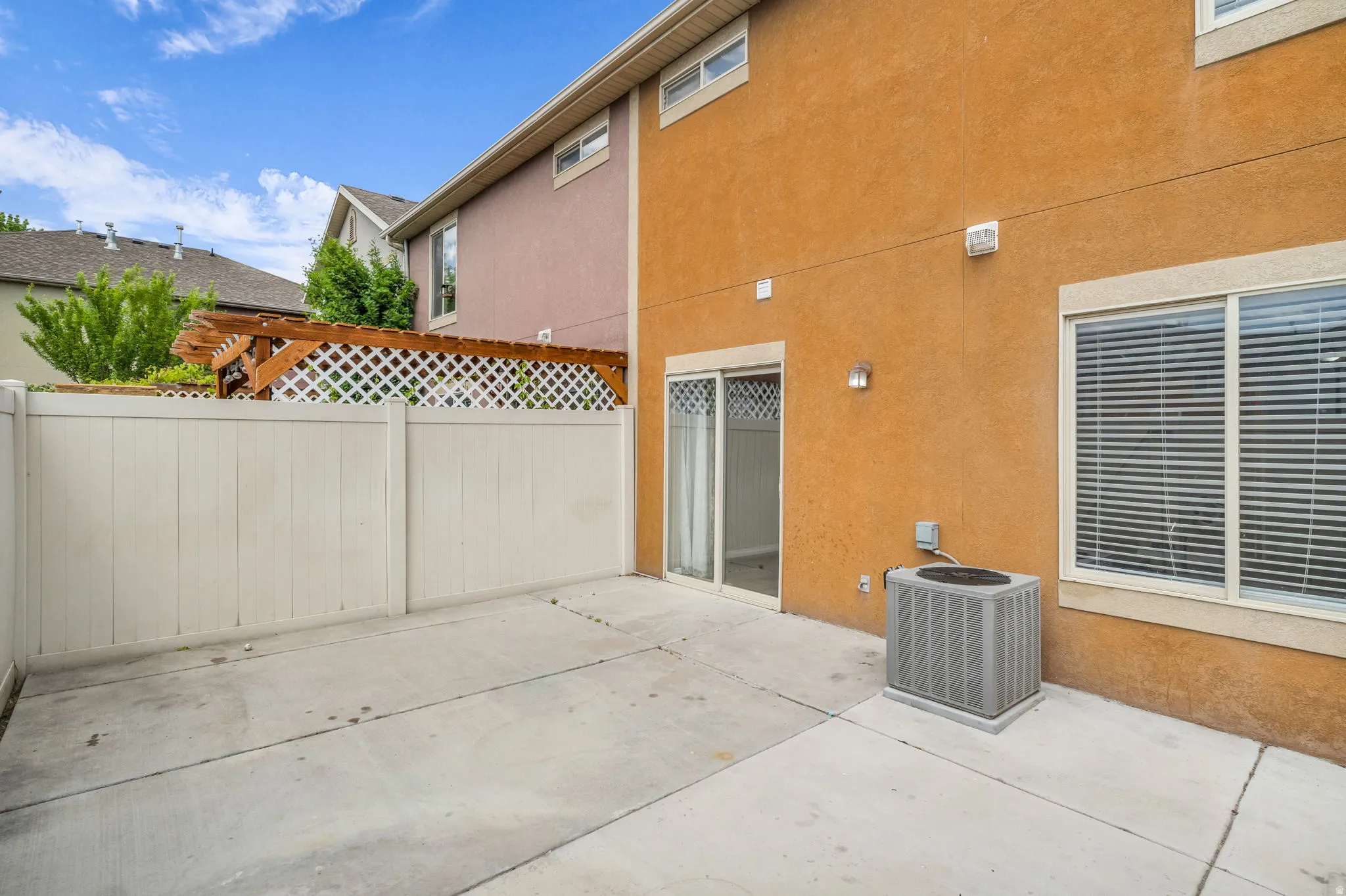 Relaxing back patio with durable concrete surfaces and enclosed privacy fencing, offering the perfect space for outdoor dining, entertaining, or quiet evenings at home.