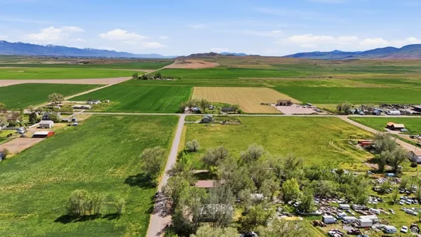 Expansive rural landscape featuring vast green fields and distant mountains