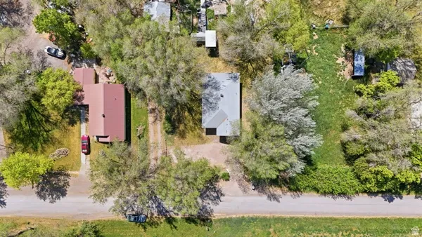 Aerial view showcasing two residential structures and expansive green space