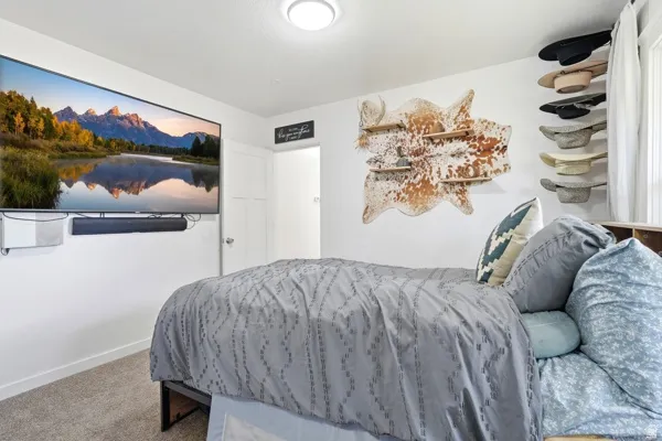 Spacious room featuring light-colored walls and carpet flooring