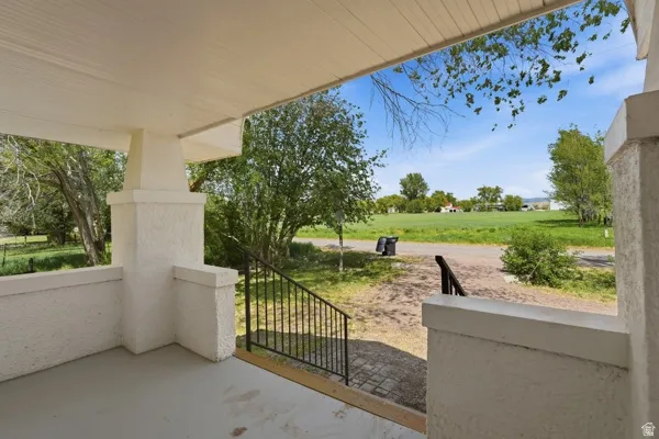 Covered porch with textured white columns and a black metal railing