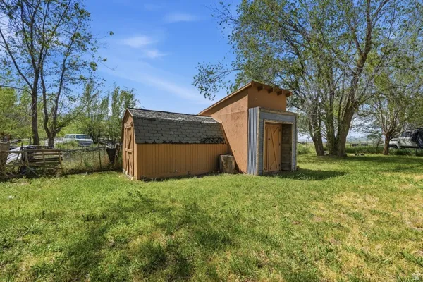 Two-structure outbuilding featuring wood siding, corrugated metal accents, and a shingled roof