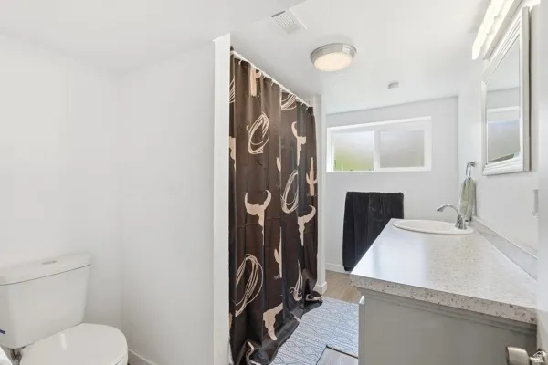 Bathroom with a light gray vanity, white countertop, and integrated sink
