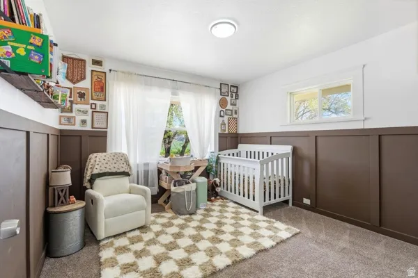 Spacious room featuring board and batten wall paneling, ceiling-mounted lighting, and a window with white trim