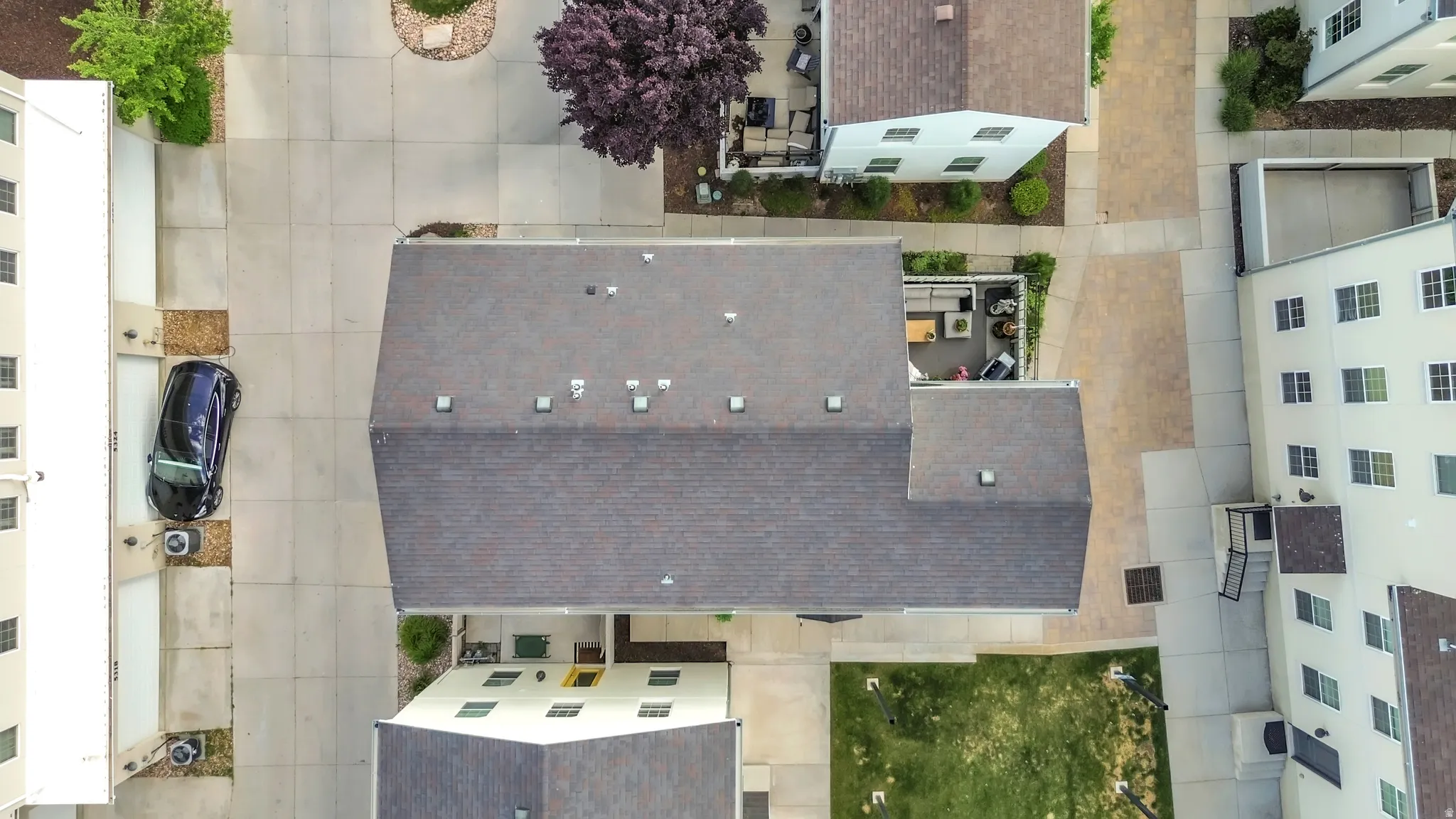 Pitched roofline on a multi-story residence, featuring a private outdoor patio area