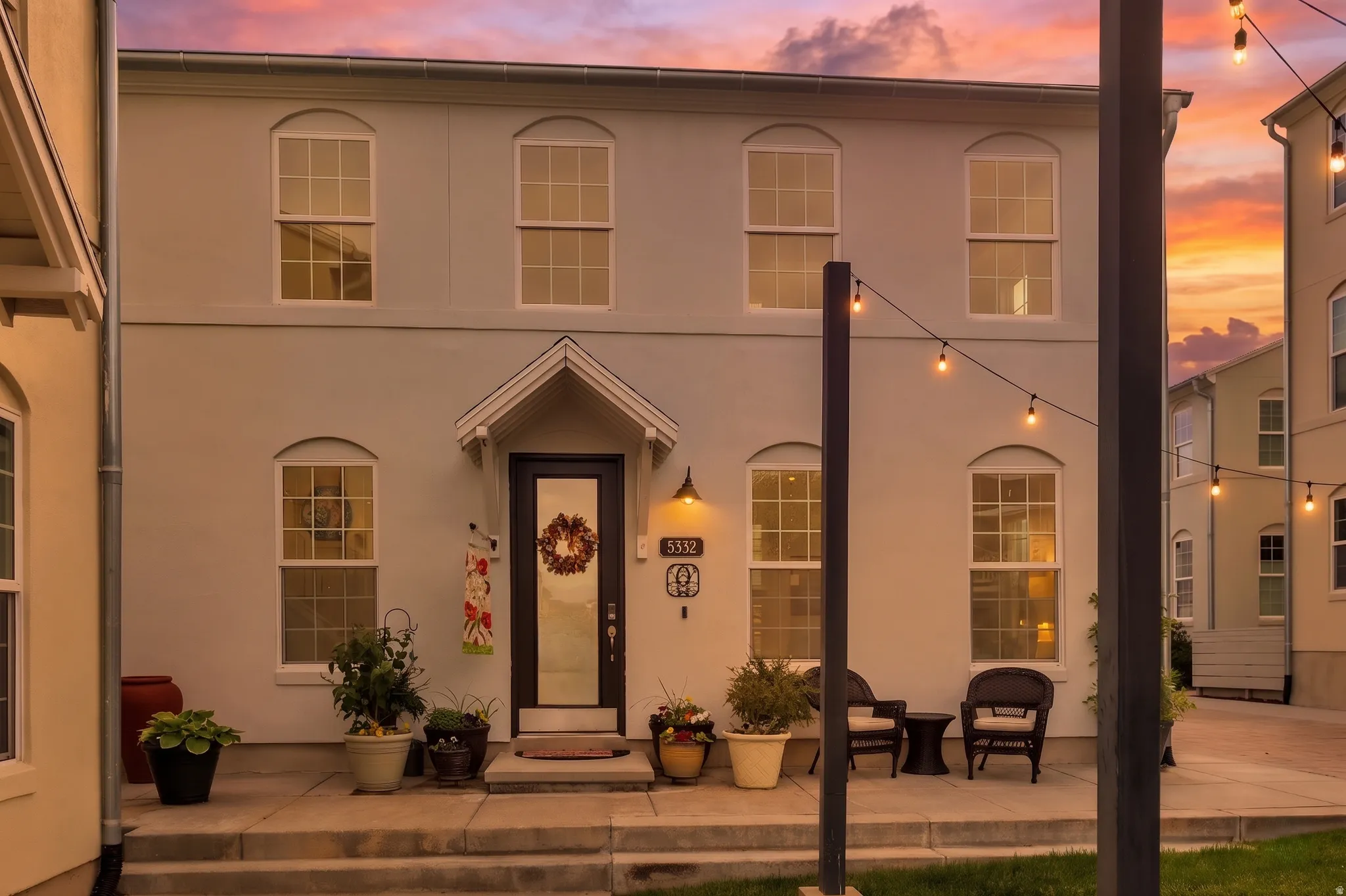 Stucco exterior featuring an inviting covered entry with a transom window