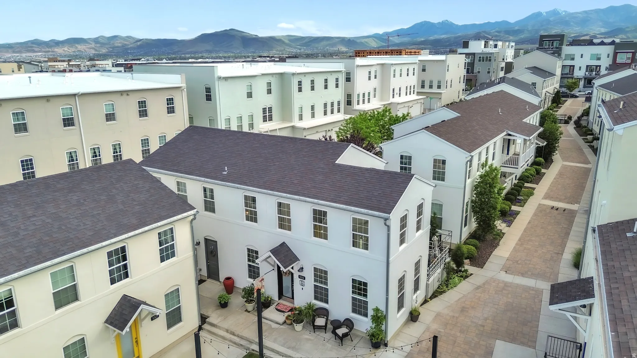 Aerial perspective showcasing a multi-story residence with white exterior siding and dark roofing