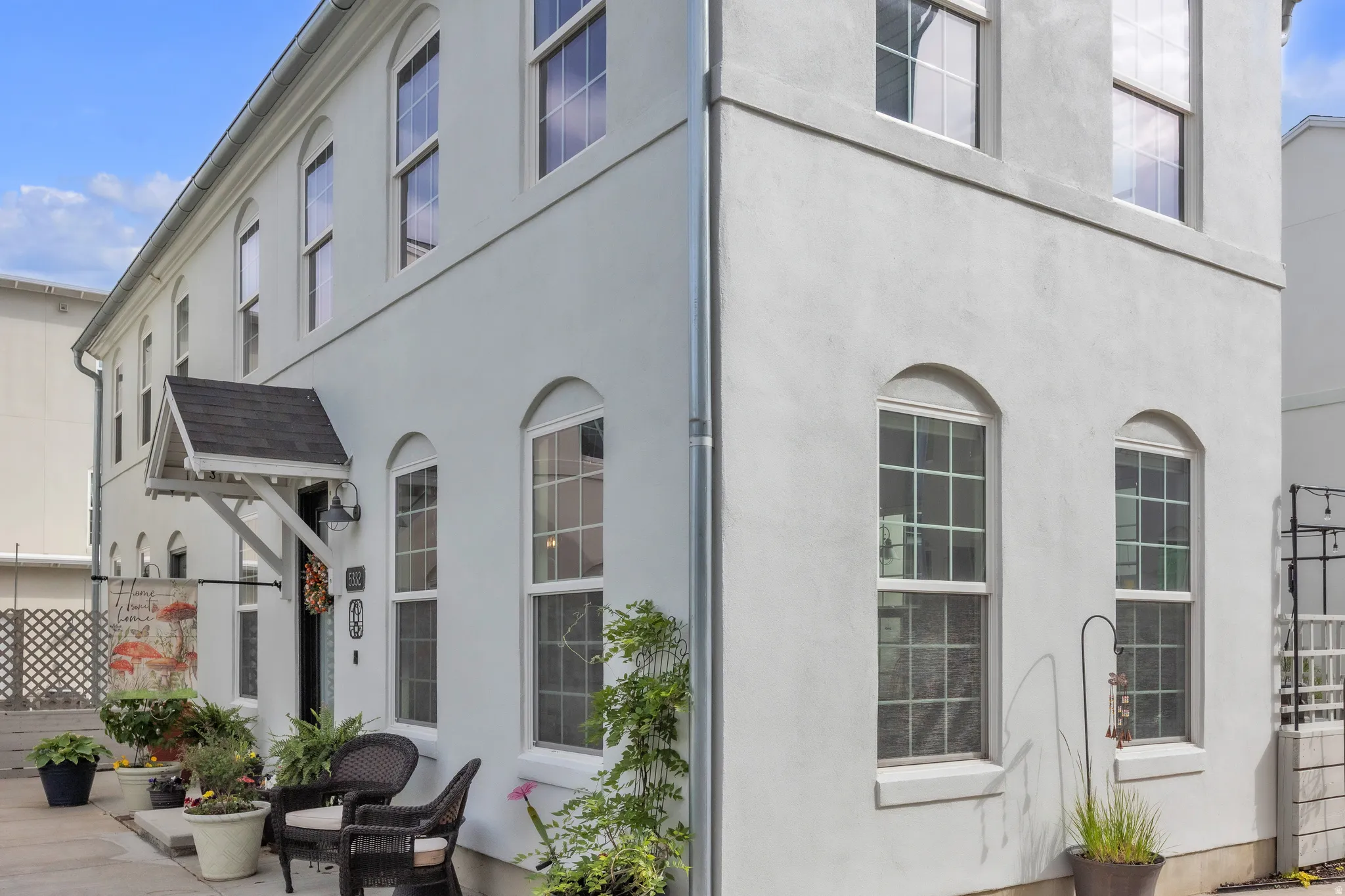 Two-story stucco exterior featuring multiple arched windows and a covered entryway