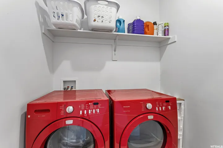 Dedicated laundry area featuring a white wall shelf, utility hookups, and a neutral wall finish