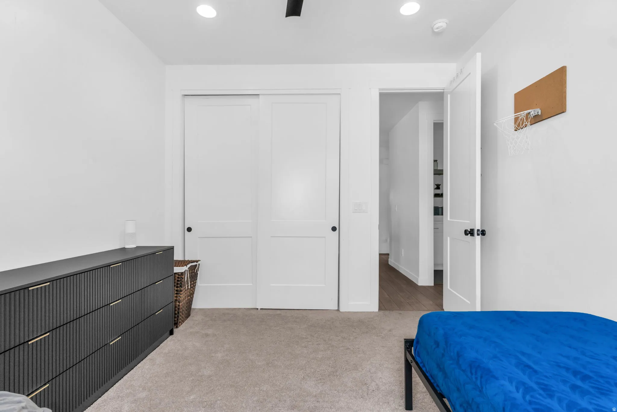 White walls with recessed lighting and a black track light fixture