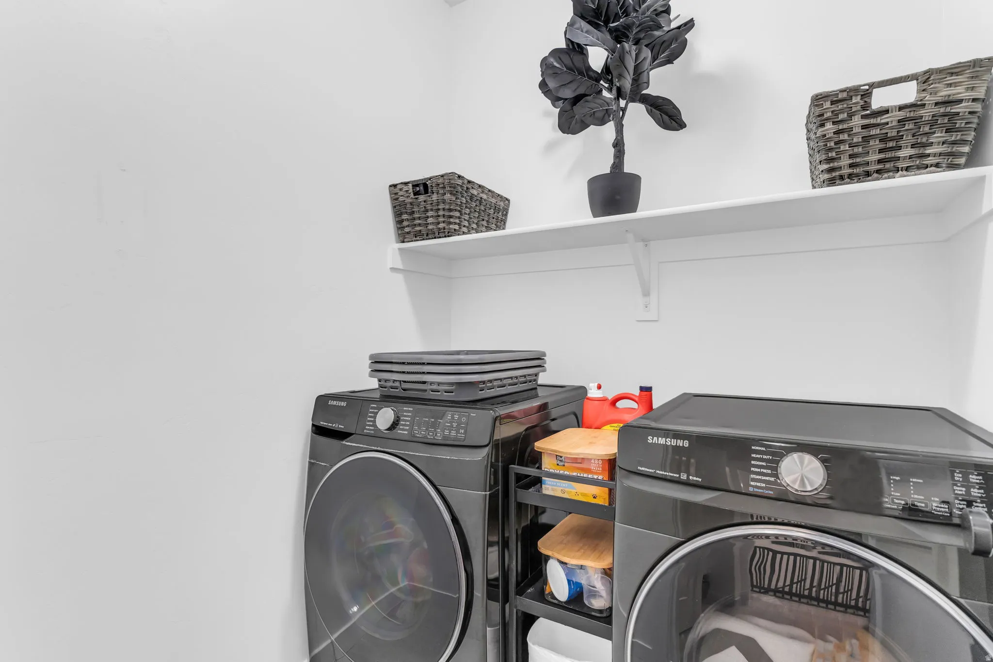 Dedicated laundry area featuring a white wall shelf