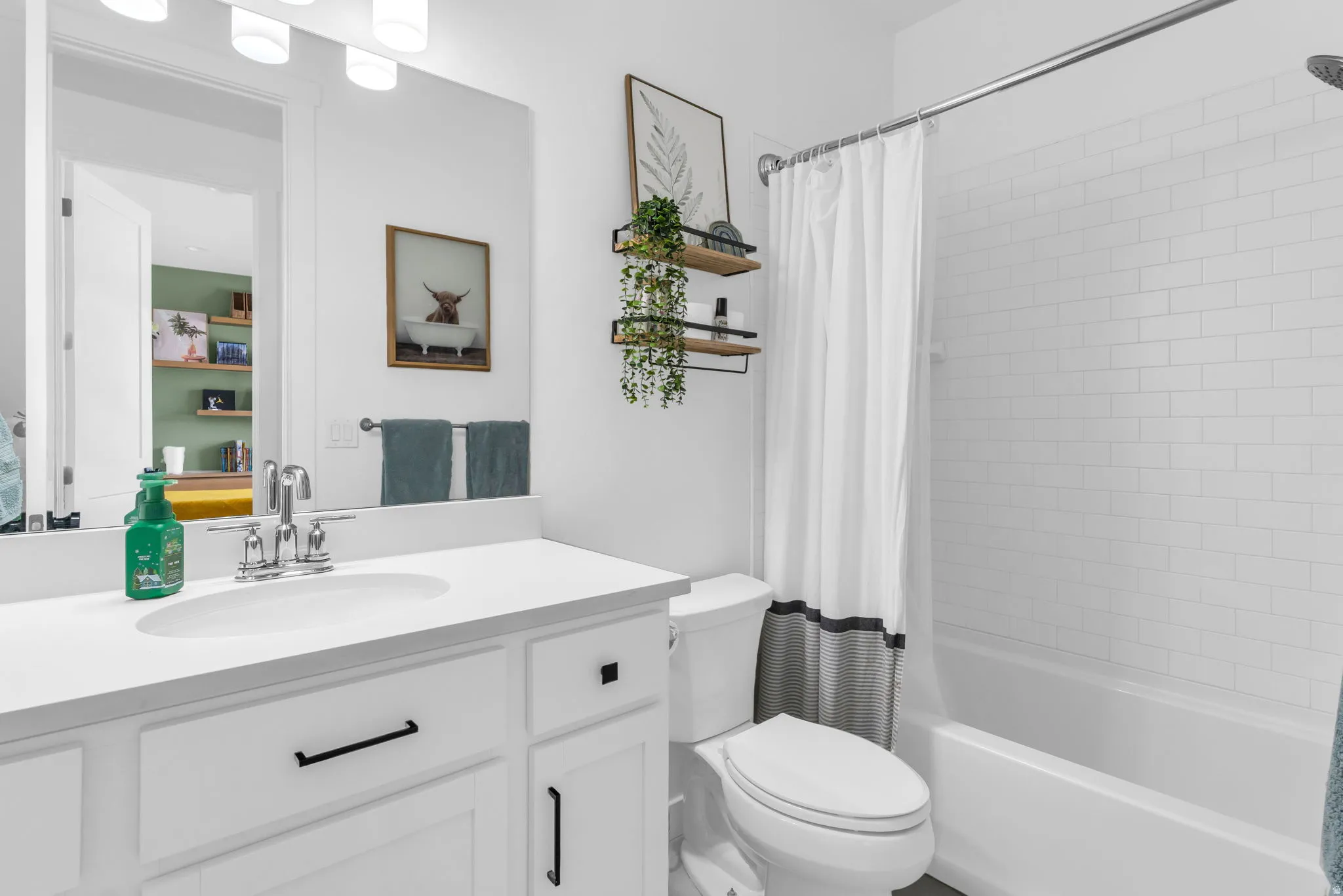 White vanity with integrated sink, chrome faucet, and black hardware