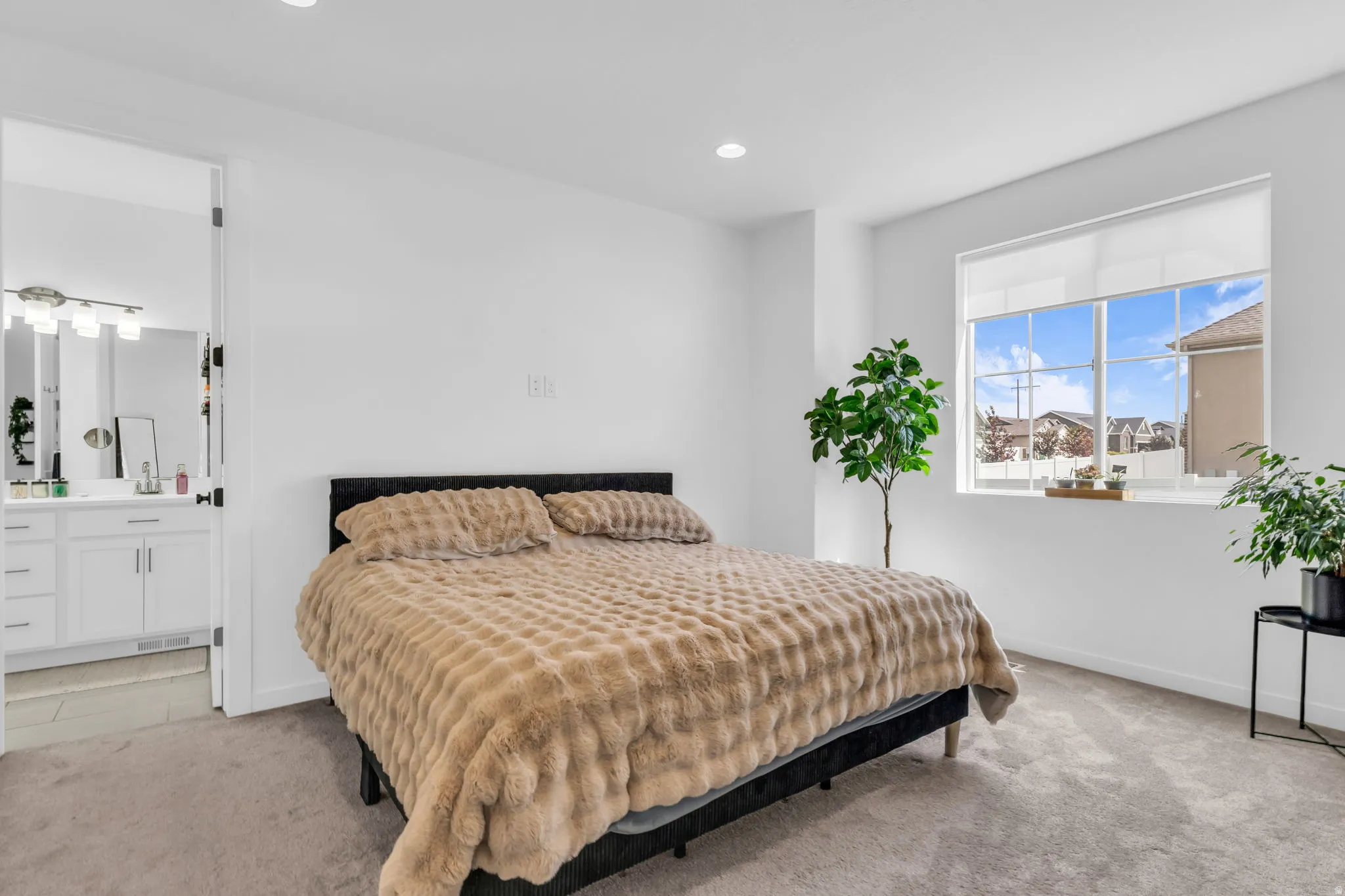 Carpeted room with a large window and recessed lighting