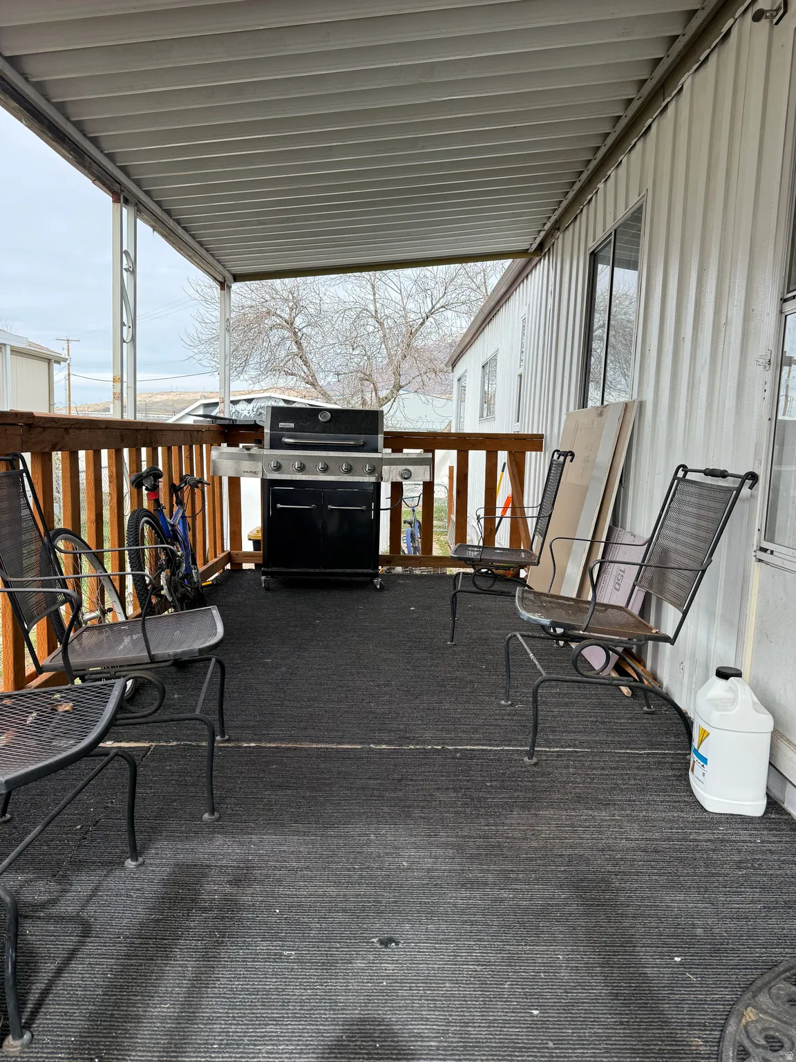 Covered outdoor deck with ribbed metal ceiling and wood railing