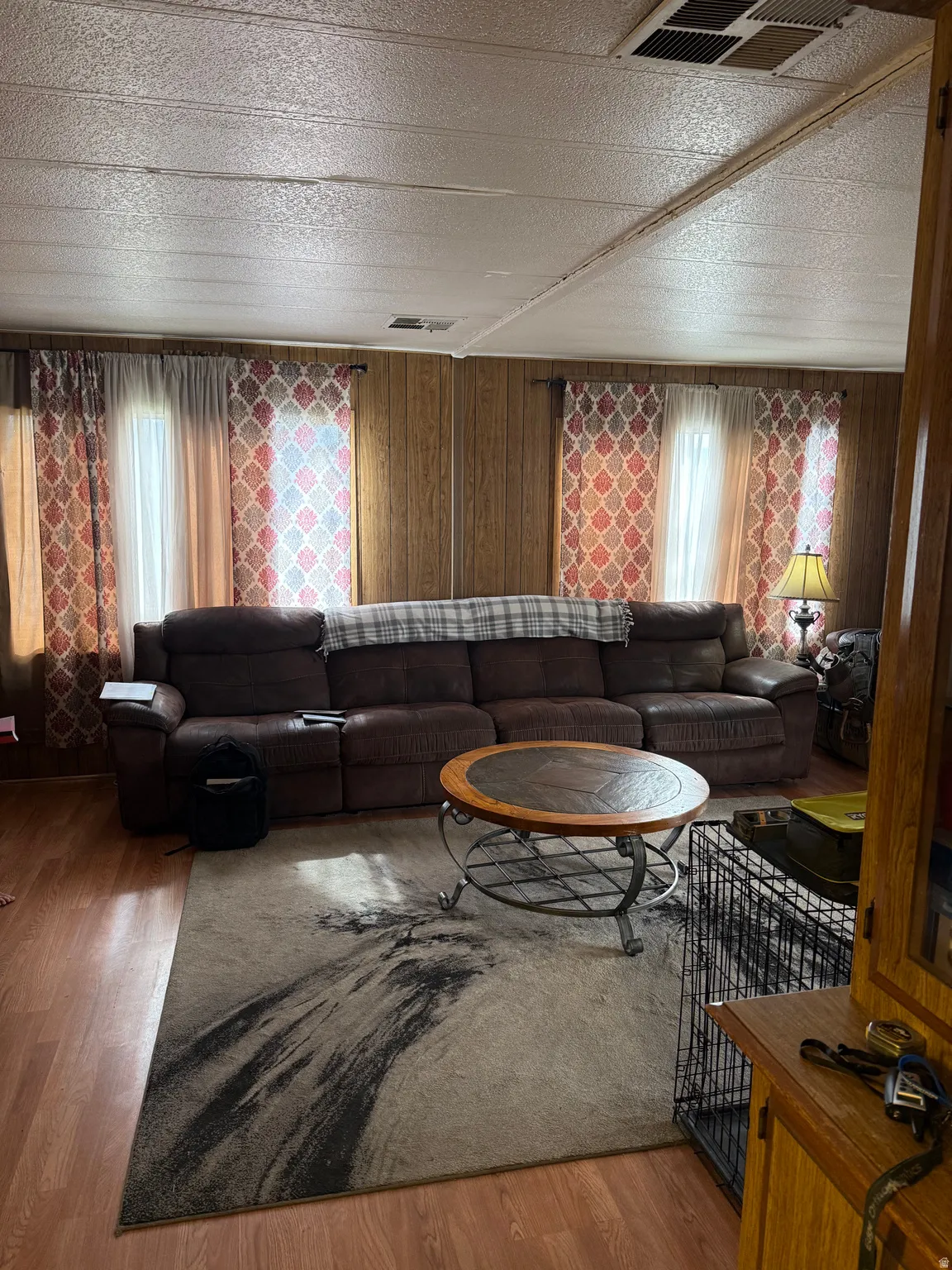 Wood-finish flooring throughout the room, complemented by wood paneling on the walls