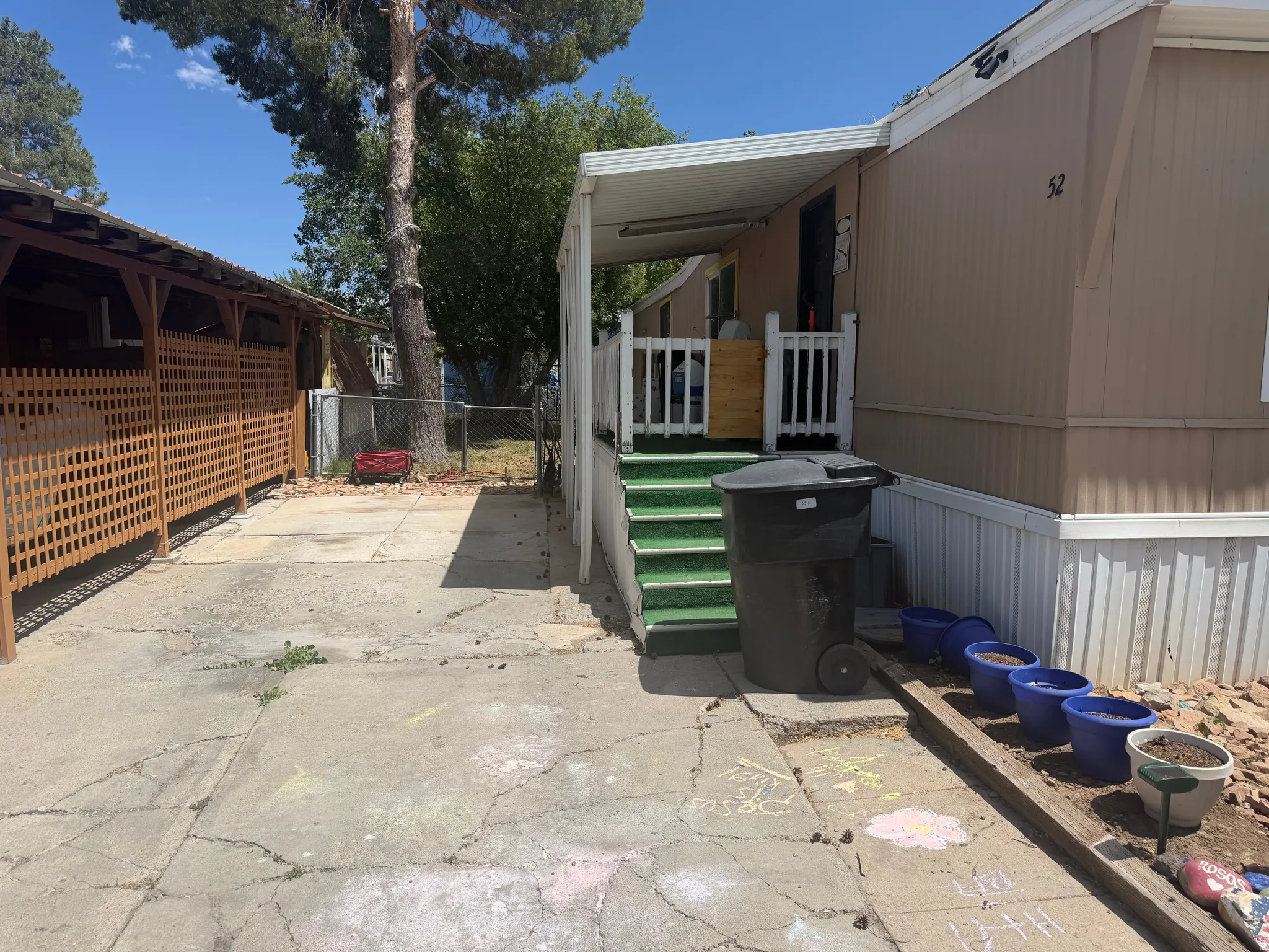 Mobile home exterior with tan siding and white trim
