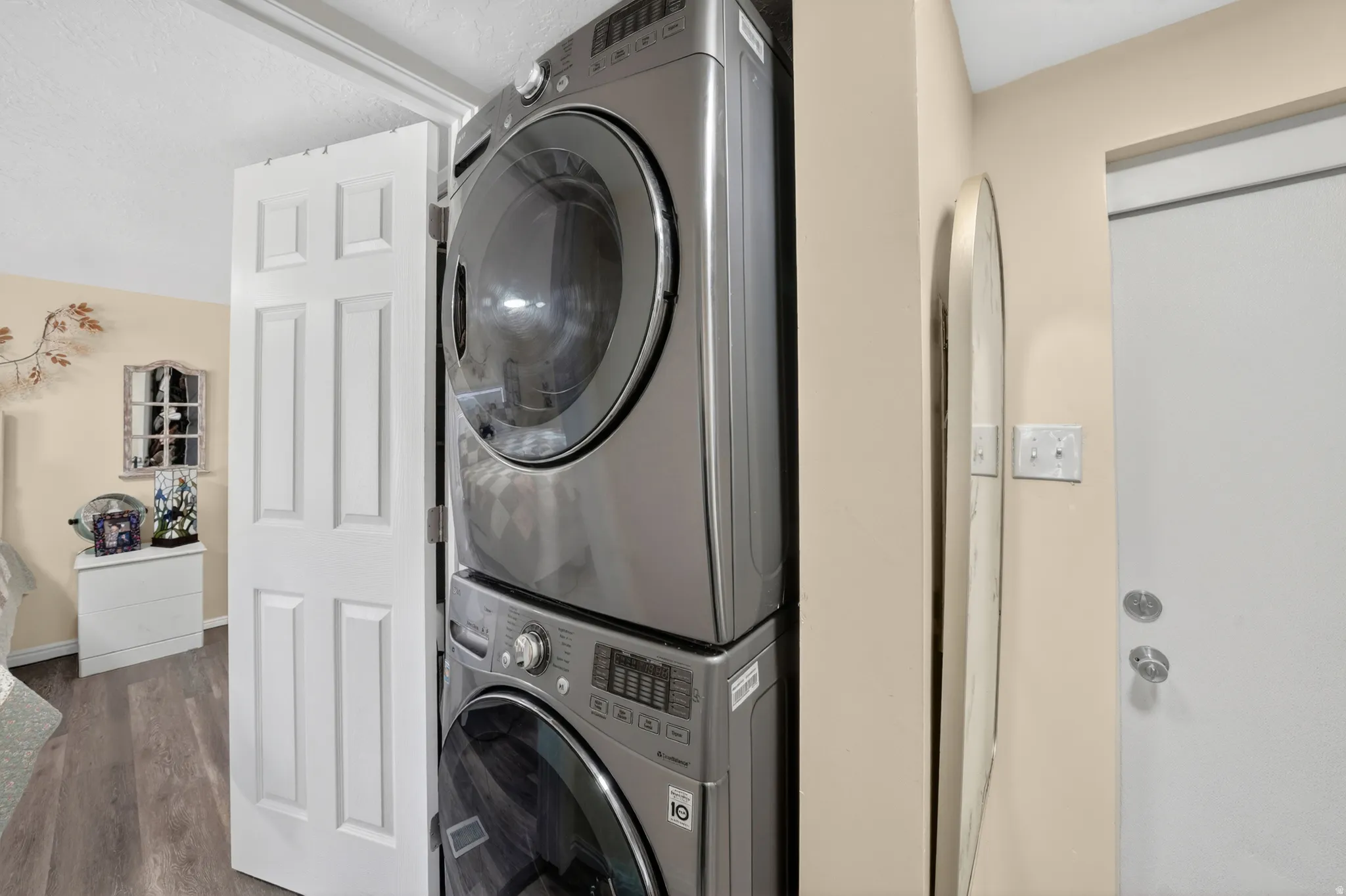 Stackable washer and dryer unit with a light wood-finish floor