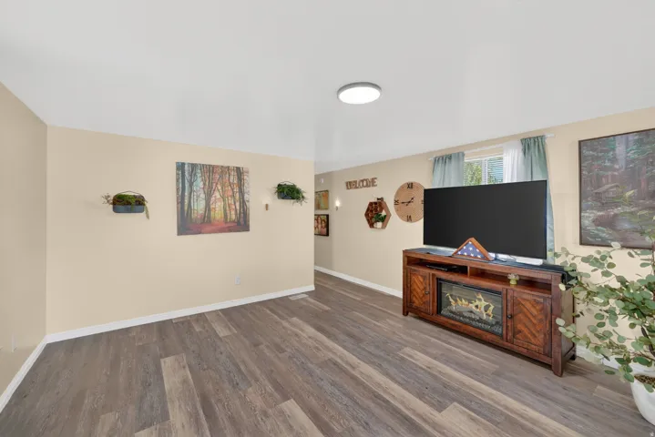 Spacious room featuring wood-finish flooring, light-toned walls, and a recessed ceiling light