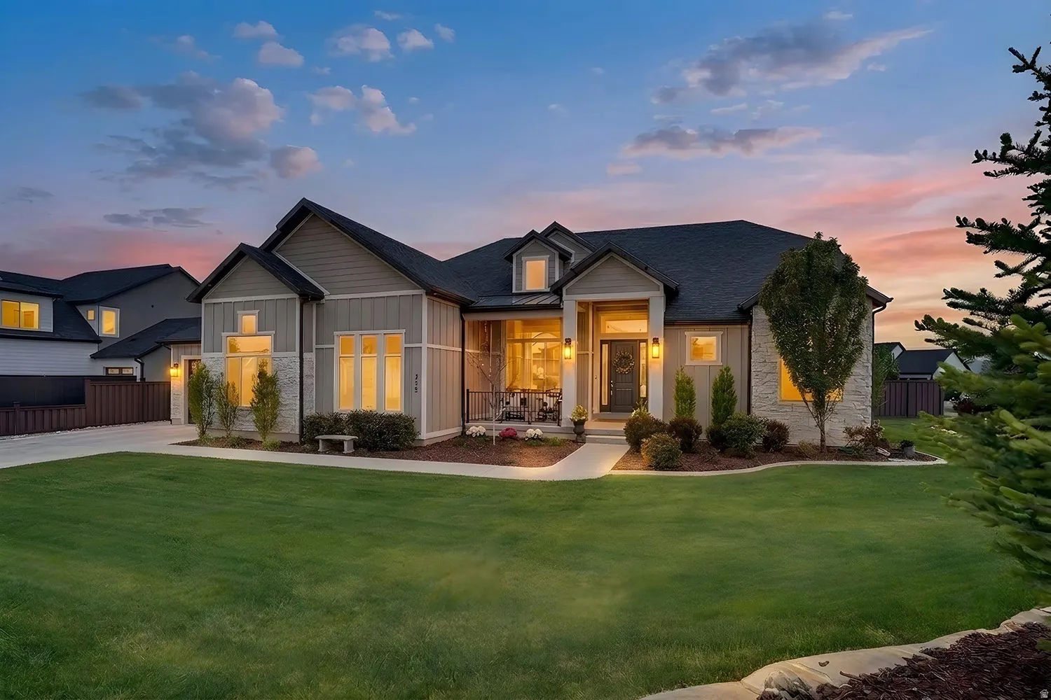 Contemporary residence featuring a prominent gabled roofline and a combination of horizontal siding and stone veneer