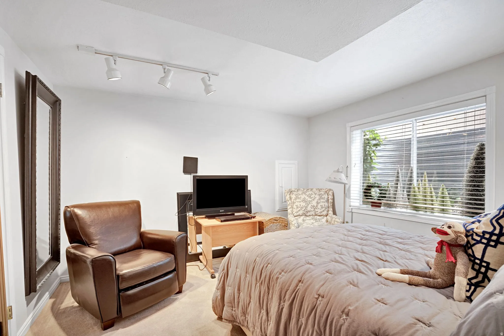 Bedroom with walk in closet and track lighting.