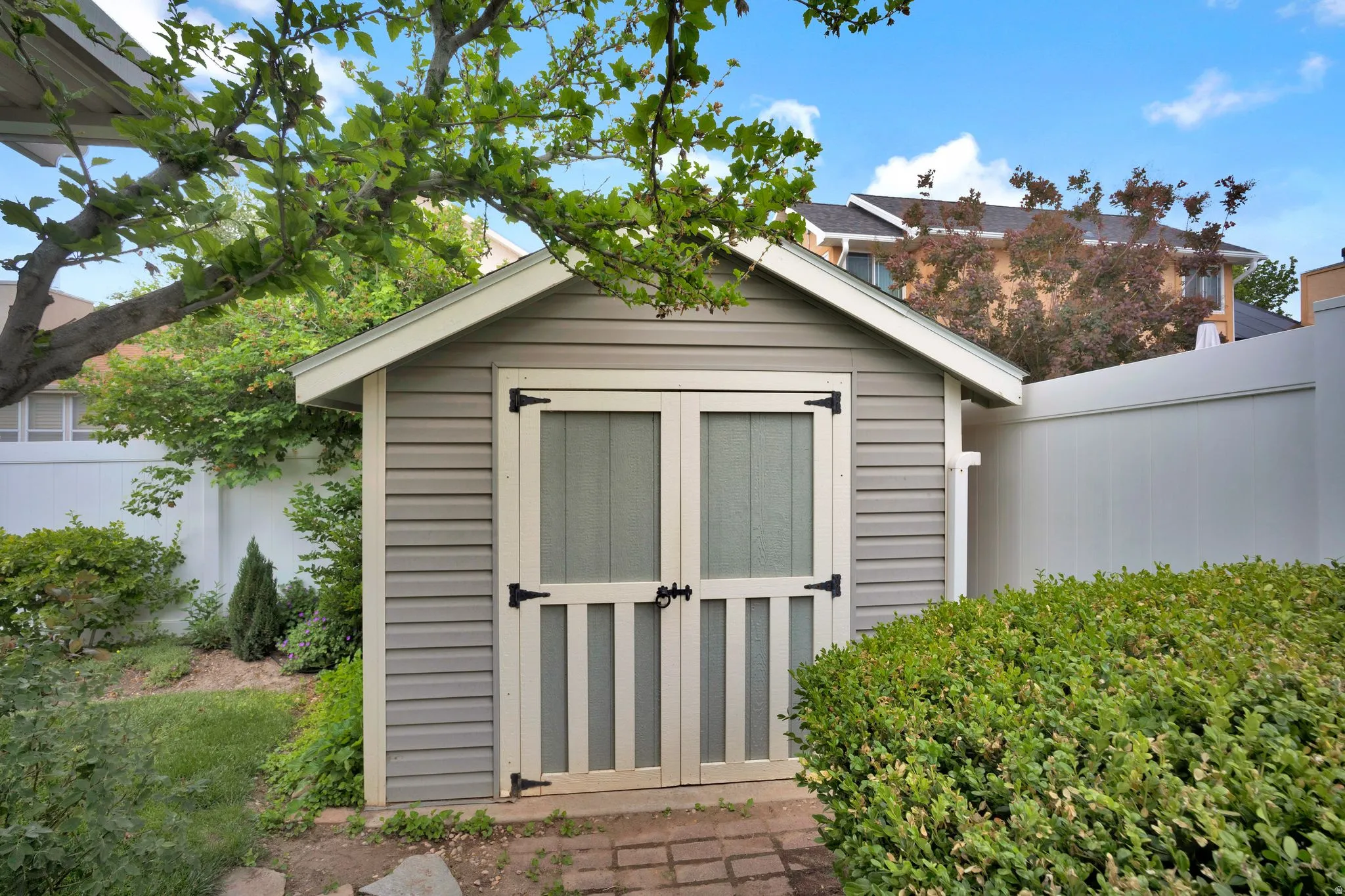 Attractive gable-roofed storage shed featuring horizontal siding and double doors with black hardware. Meticulously stick built.