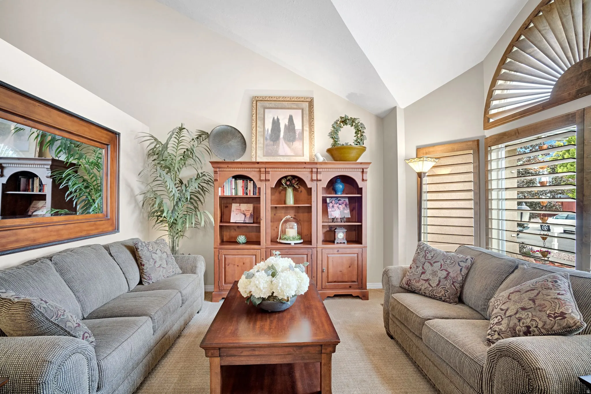 Living area featuring vaulted ceilings and neutral wall tones.  Quality wood plantation shutters throughout main floor.