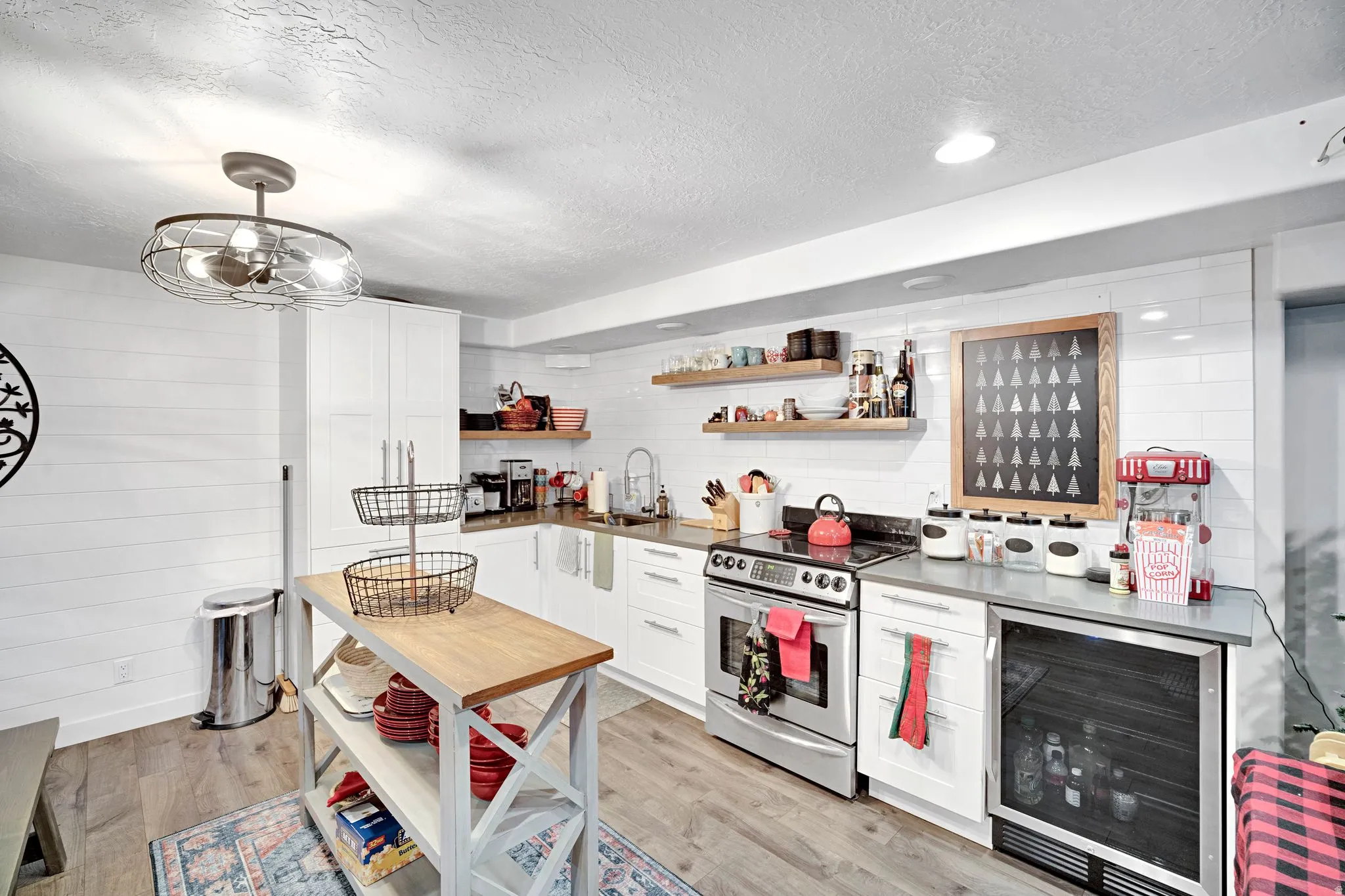 Light wood-finish flooring complements white shiplap wall accents and white cabinetry.