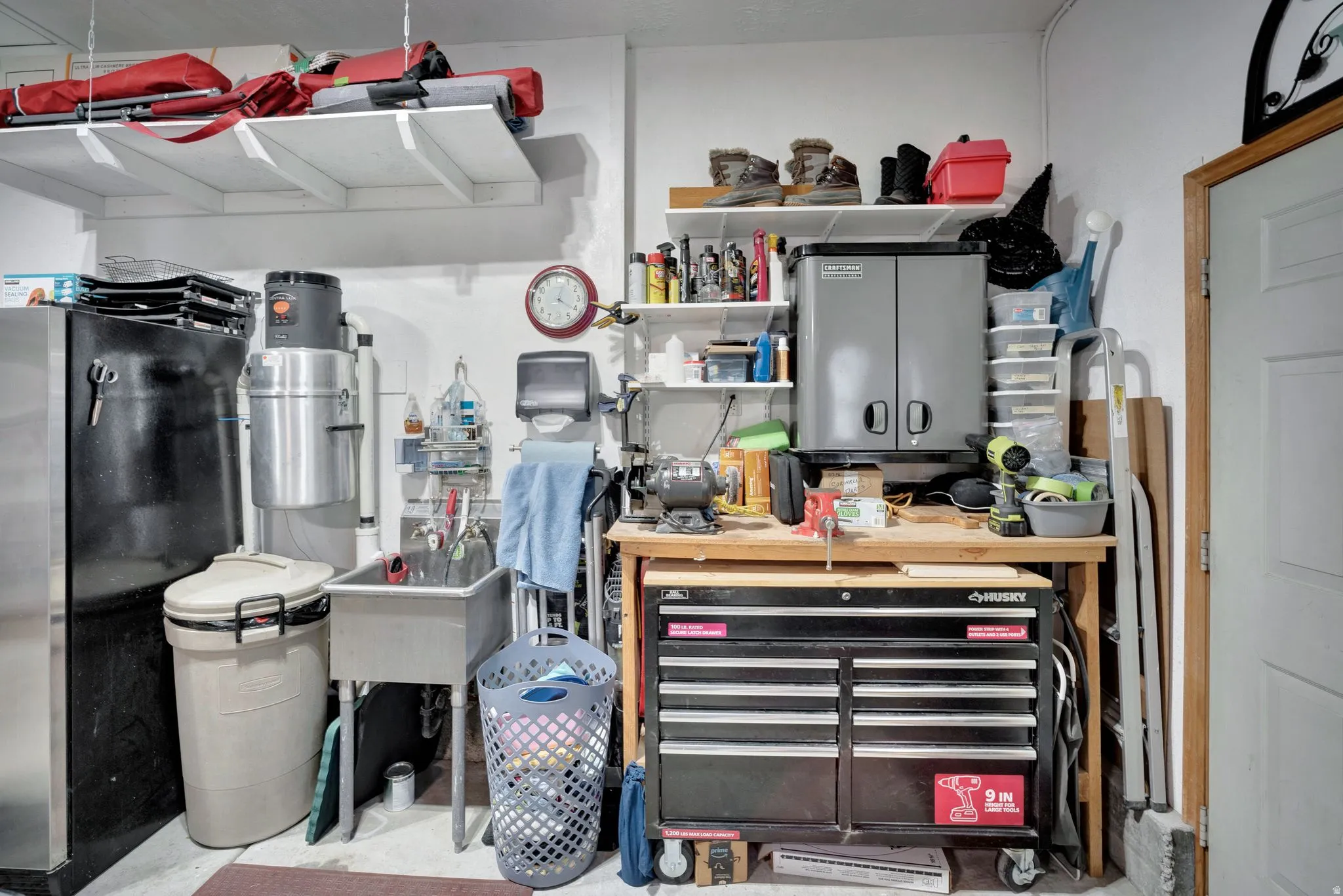 Utility sink, built in workbench (toolbox excluded),  wall-mounted cabinet and shelving, garage also has attic space storage with a pull down ladder for easy access.