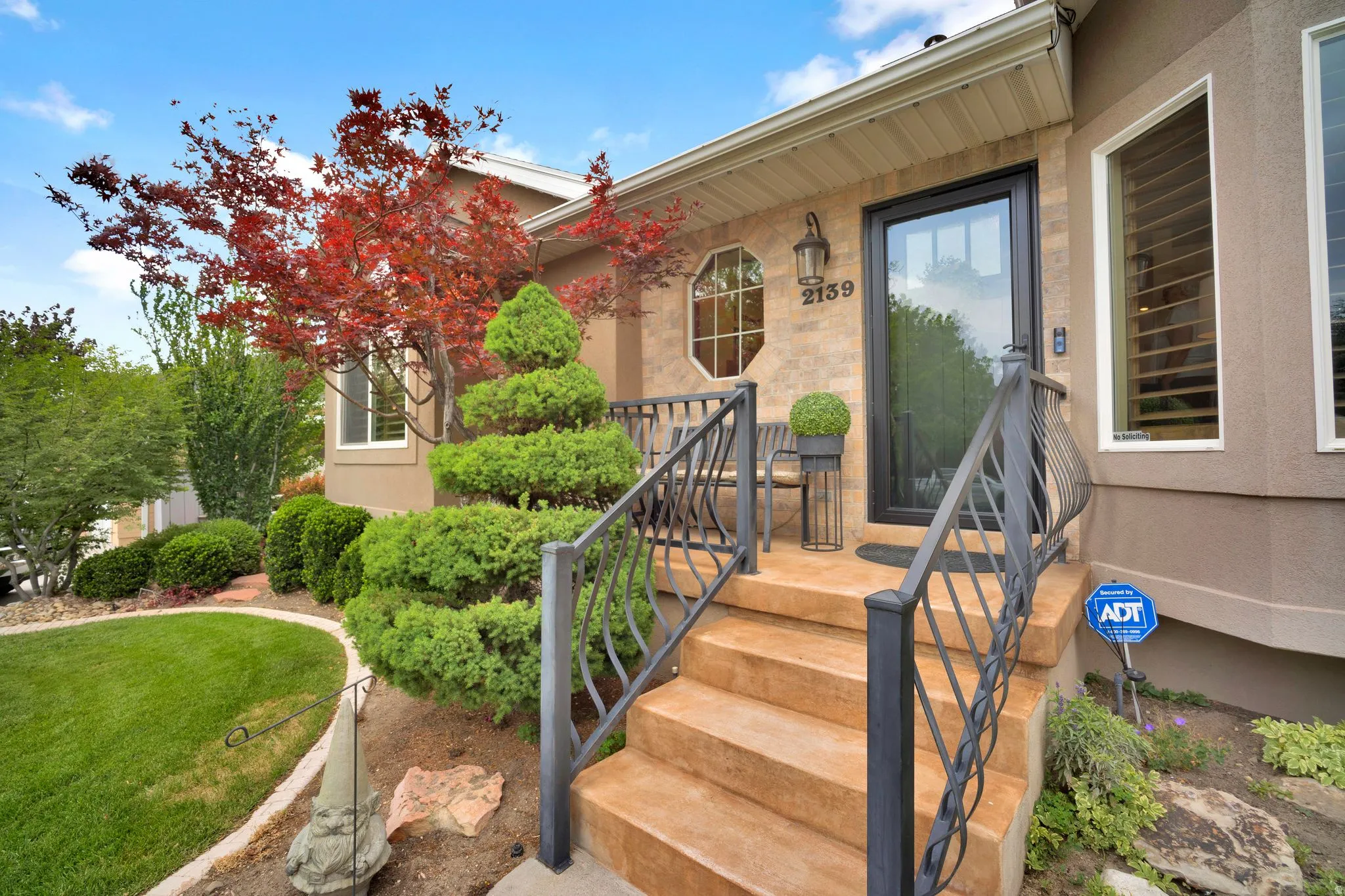 Stained concrete steps and porch.  Updated beautiful railing, newer windows on front of house with new Anderson front door and storm door. Permanent holiday lighting.