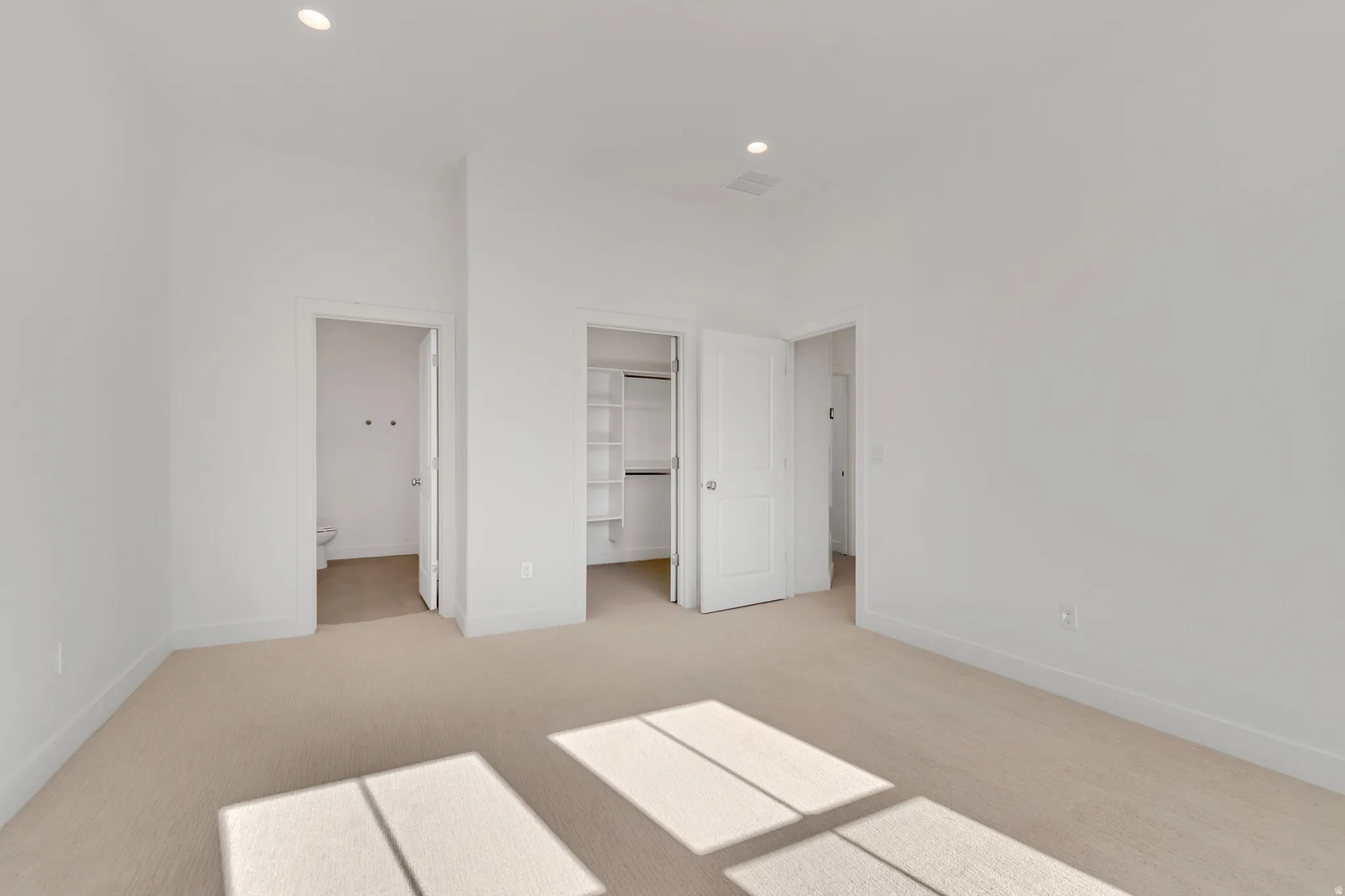 Spacious room featuring neutral carpeting, recessed lighting, white walls, and white trim