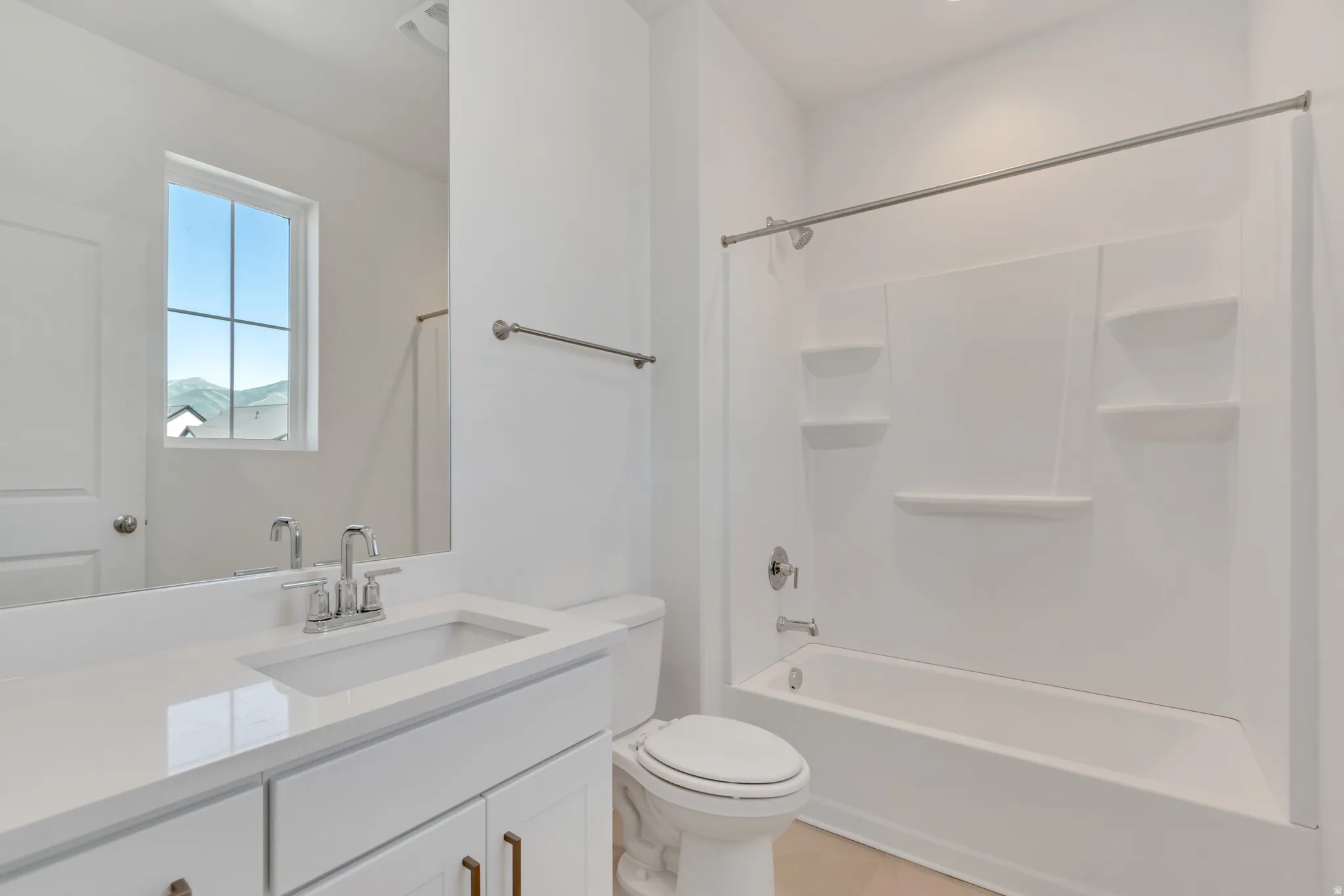 Bathroom featuring a white vanity with an integrated sink, polished chrome faucet, and quartz-finish countertop