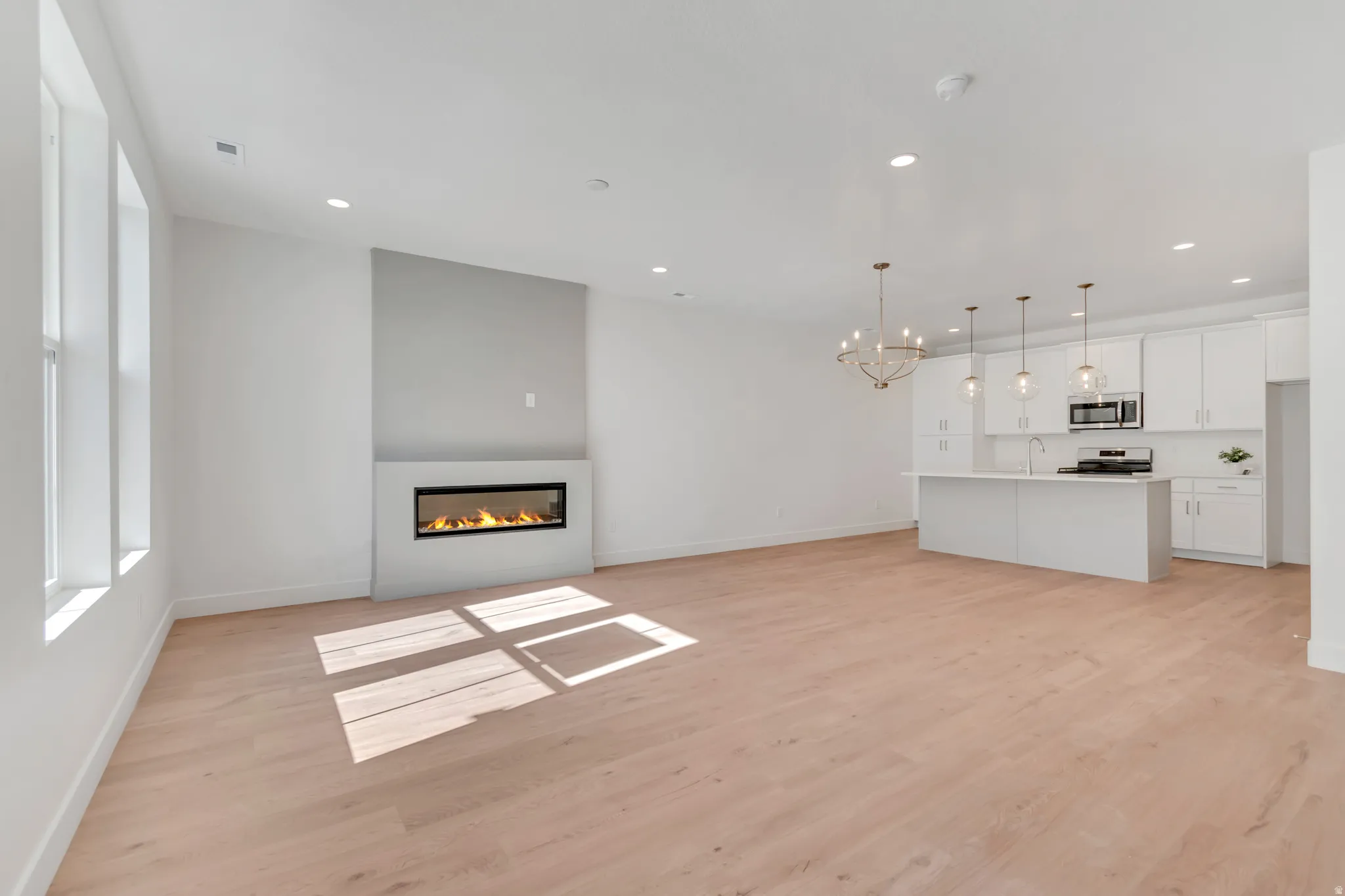 Open-concept living area with light wood-finish flooring
