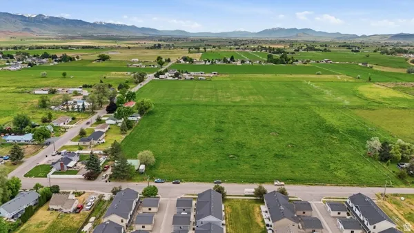 Expansive green fields surrounded by distant mountains