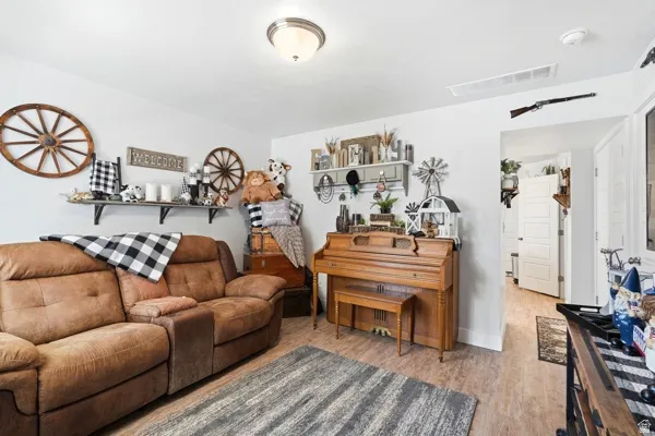 Living space featuring wood-finish flooring, white walls, and a flush-mount ceiling light