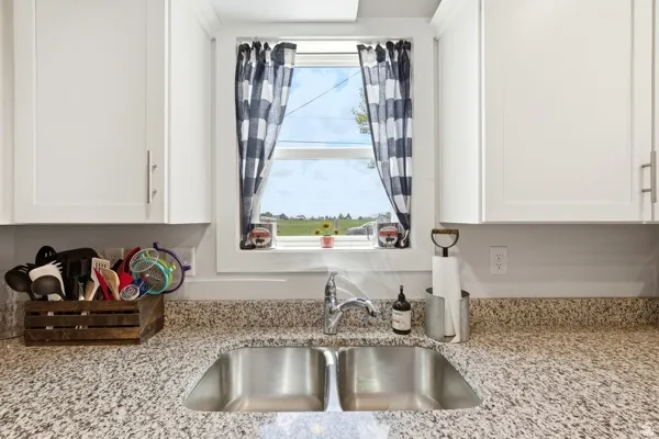 Stainless steel double basin sink with a chrome faucet, set against a speckled stone-finish countertop