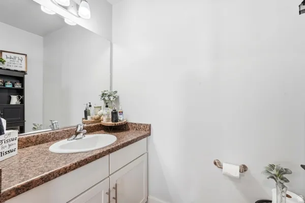 Bathroom vanity featuring a white oval sink, chrome faucet, and a large mirror