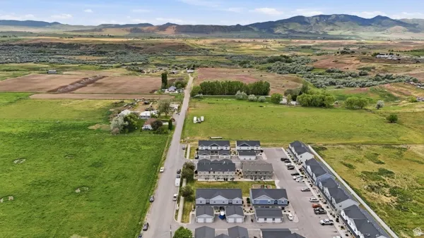 Aerial perspective showcasing a residential development with multiple unit types, paved parking areas, and mature trees