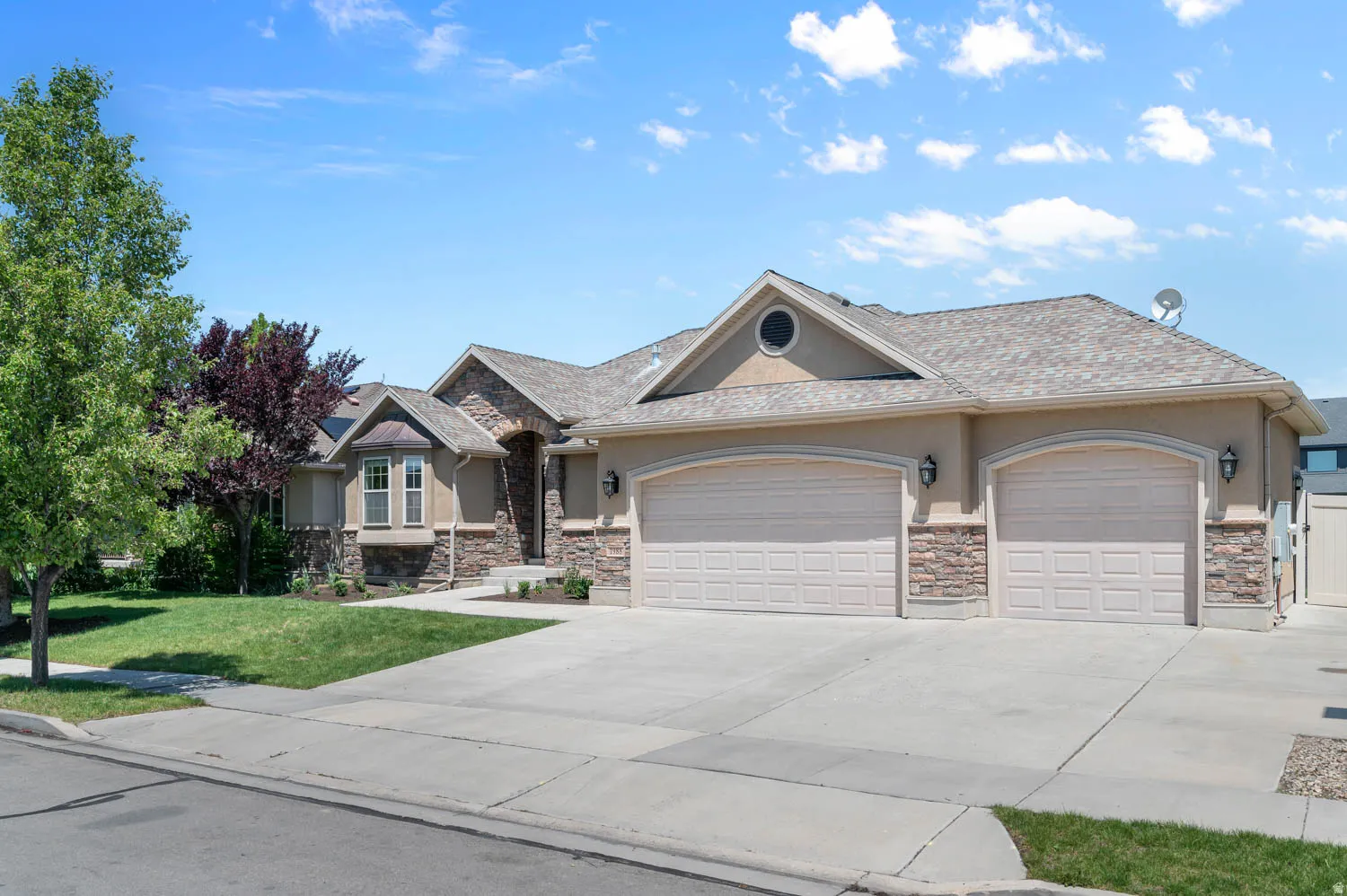 Stucco exterior with stone accents and a multi-gabled roofline