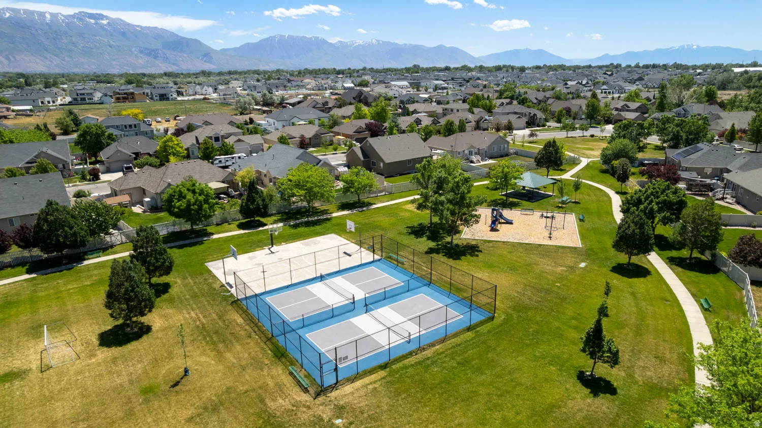 Community park featuring multiple amenities including sports courts, playground area, and walking paths