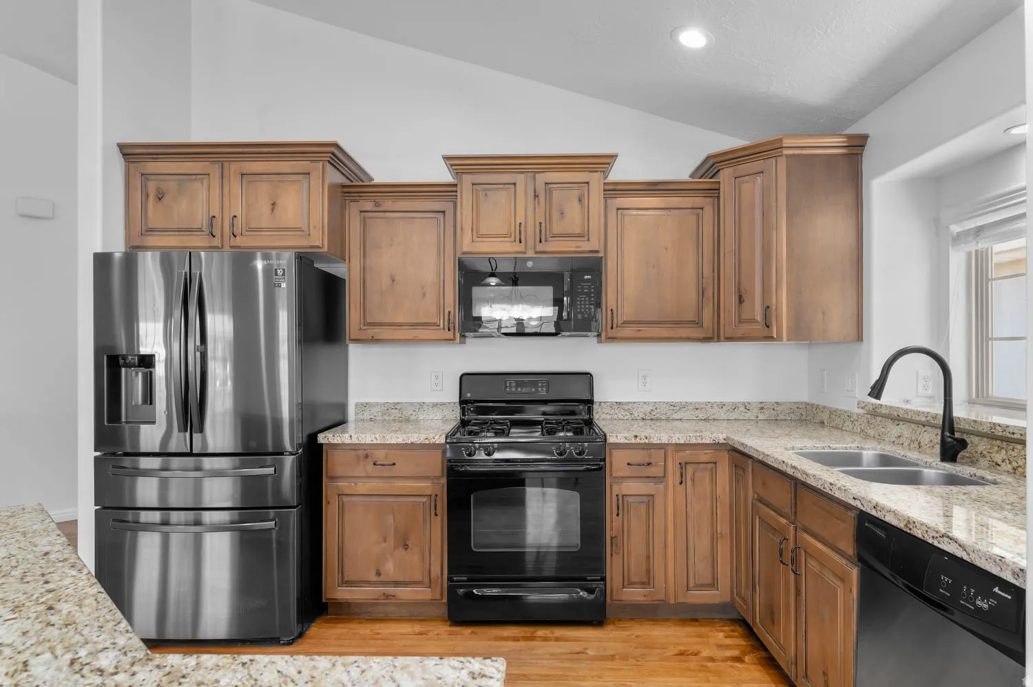 Kitchen featuring light wood-finish cabinetry, granite countertops, and stainless steel appliances
