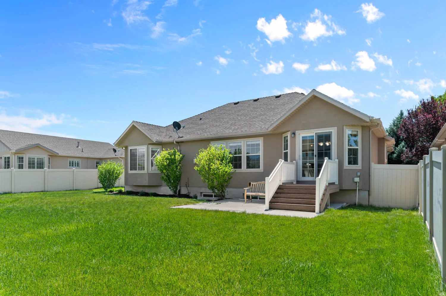 Expansive green lawn with a stucco exterior