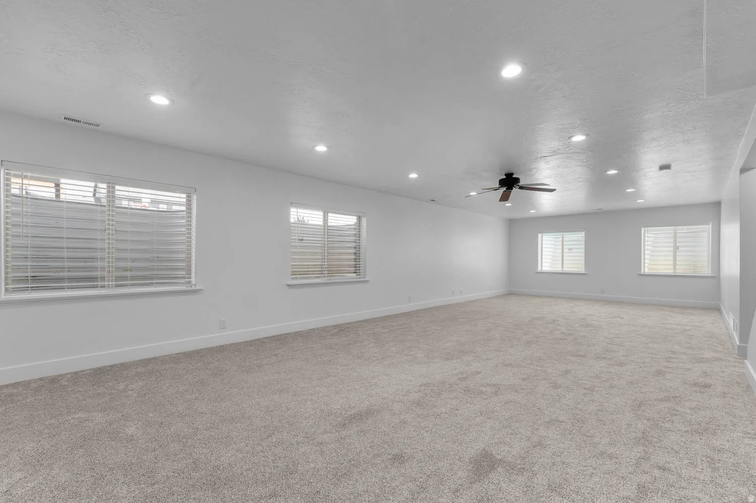 Spacious room featuring neutral carpeting and white painted walls
