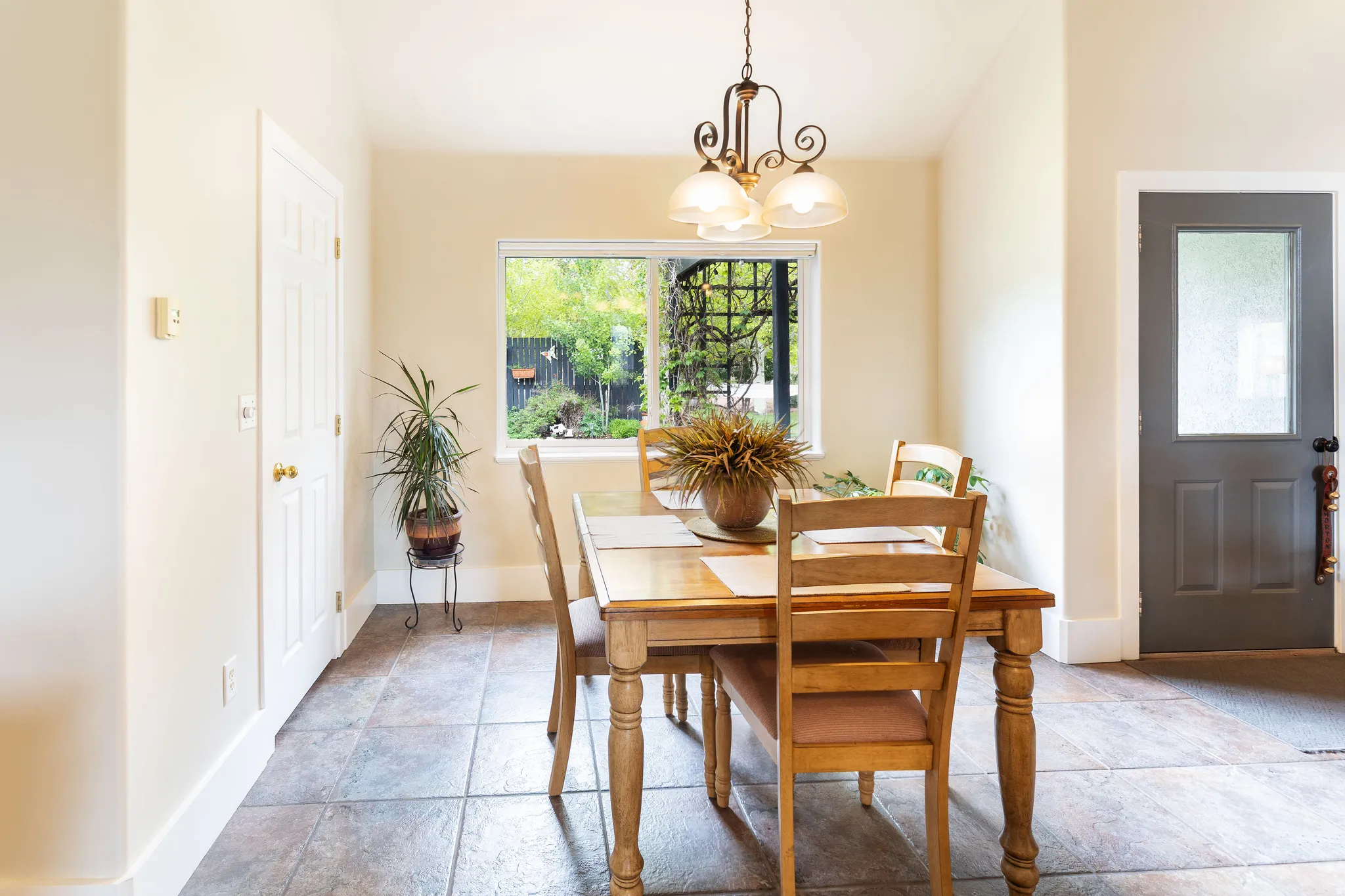 Dining area featuring a central window, warm neutral wall tones, and tiled flooring