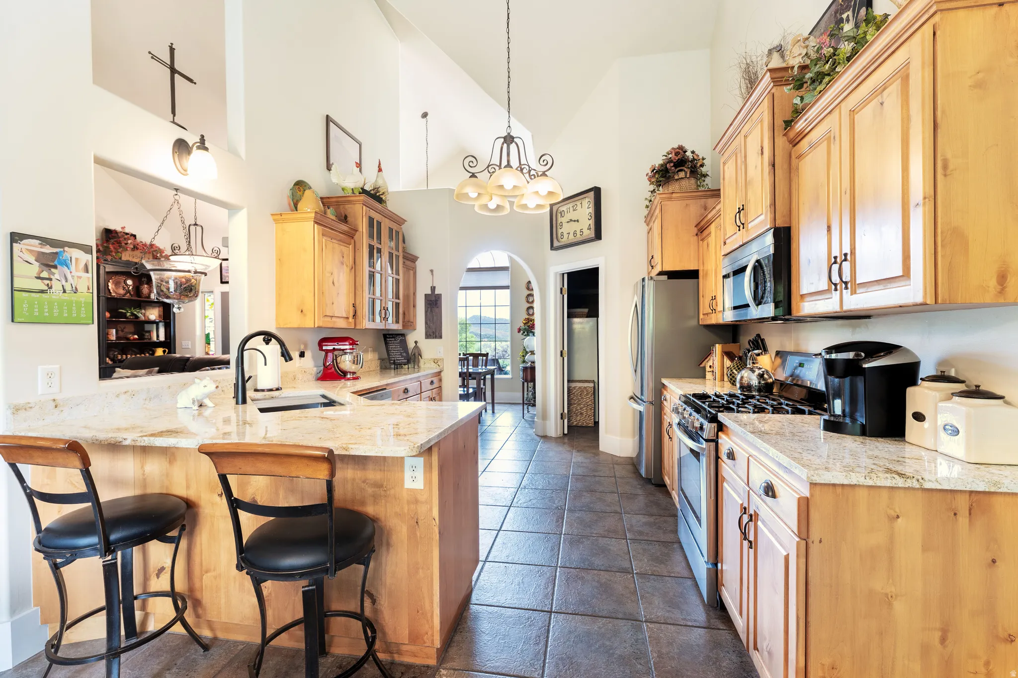 Kitchen featuring alder cabinetry, granite countertops, stainless steel appliances, and tile flooring