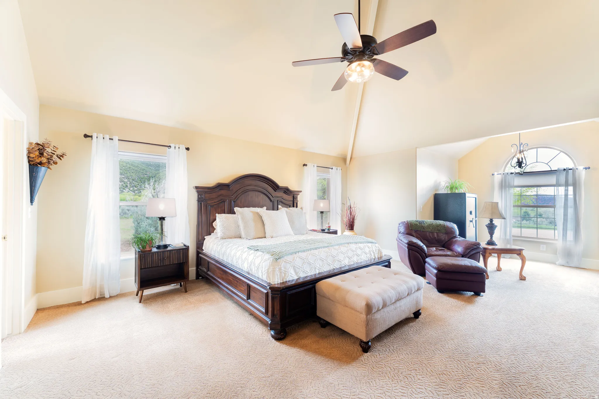 Spacious master bedroom featuring vaulted ceilings, a ceiling fan