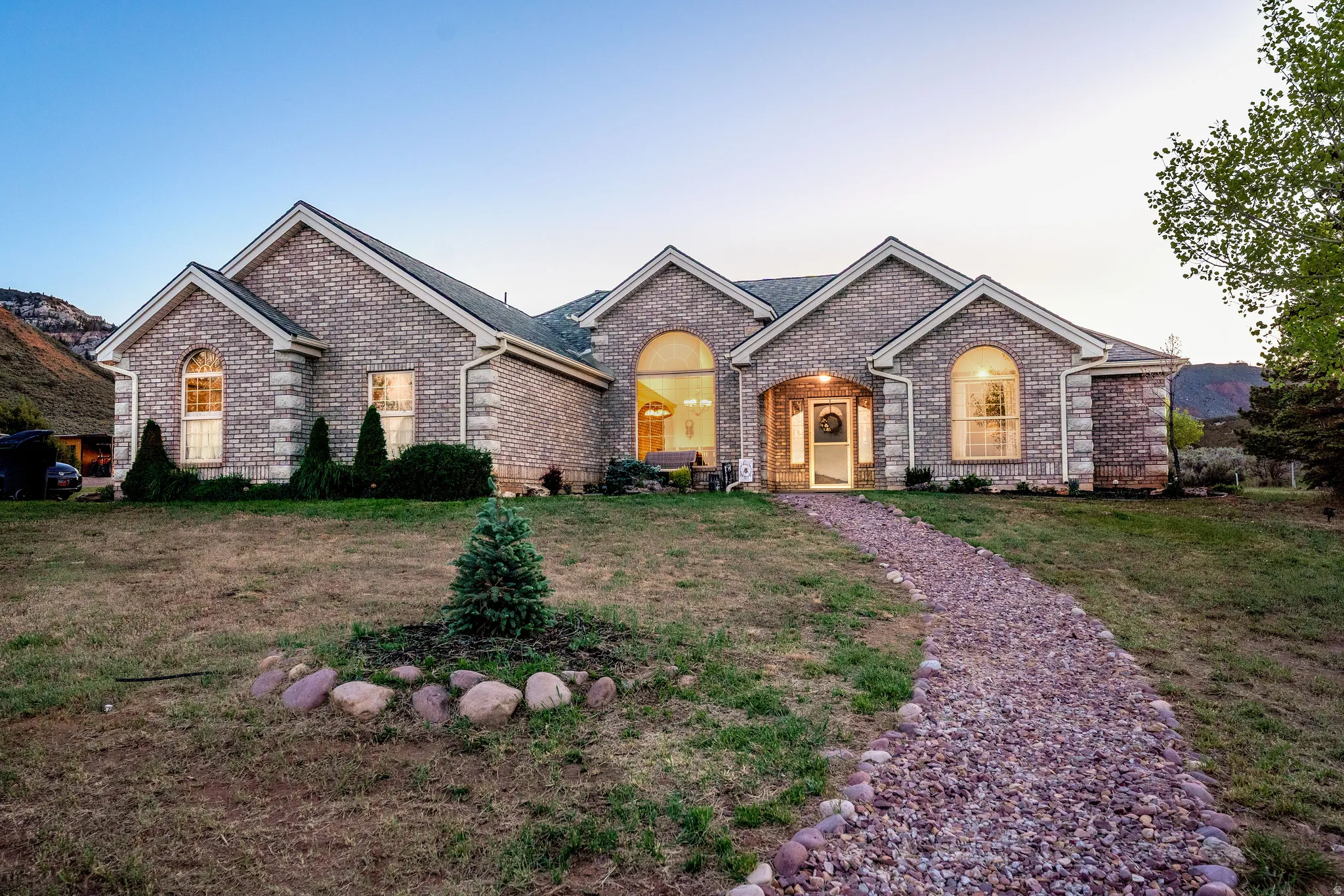 Brick exterior residence featuring arched windows and gabled rooflines