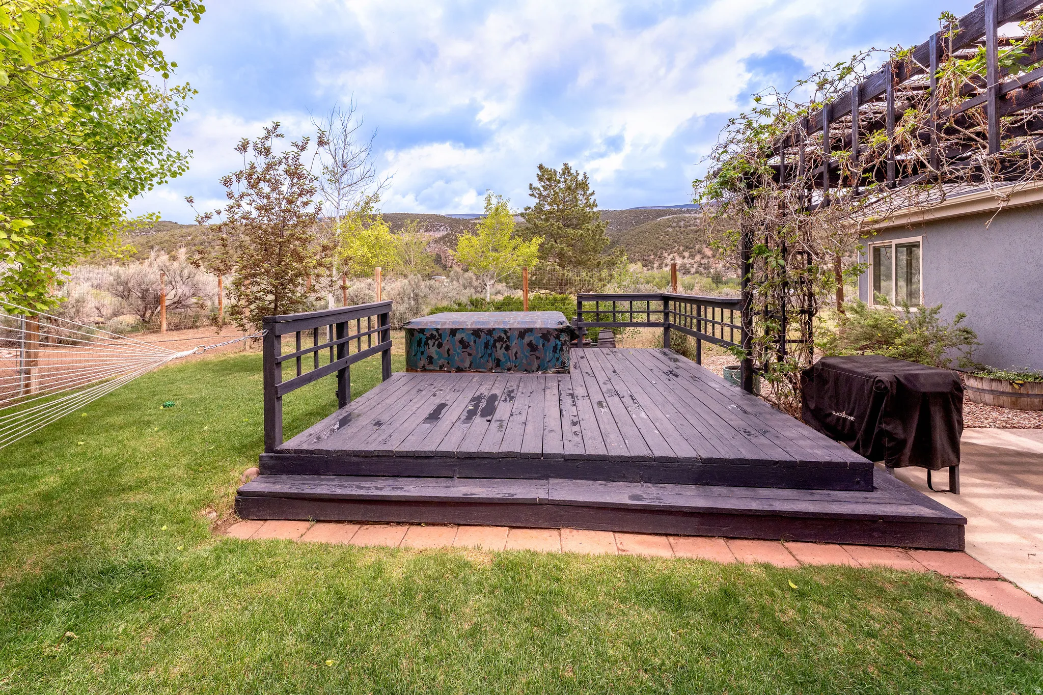 Expansive wooden deck with railing and hot tub
