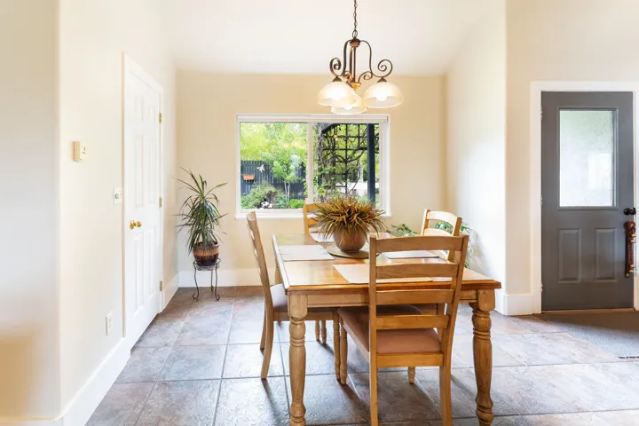 Dining area featuring a central window, warm neutral wall tones, and tiled flooring