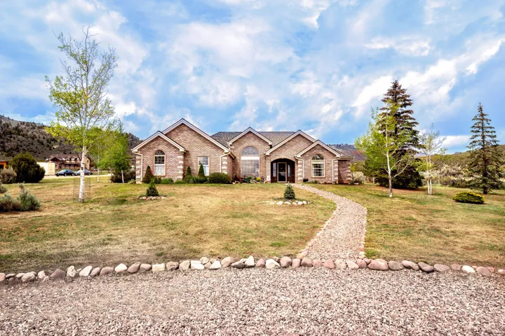 Brick facade residence with a gravel pathway, arched windows, and a multi-level roofline