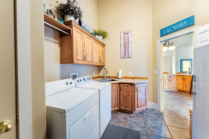 Laundry area featuring alder cabinetry, a utility sink, and ample countertop space